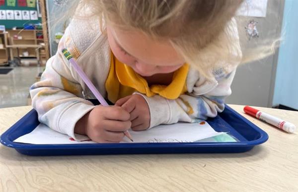 student writing on paper